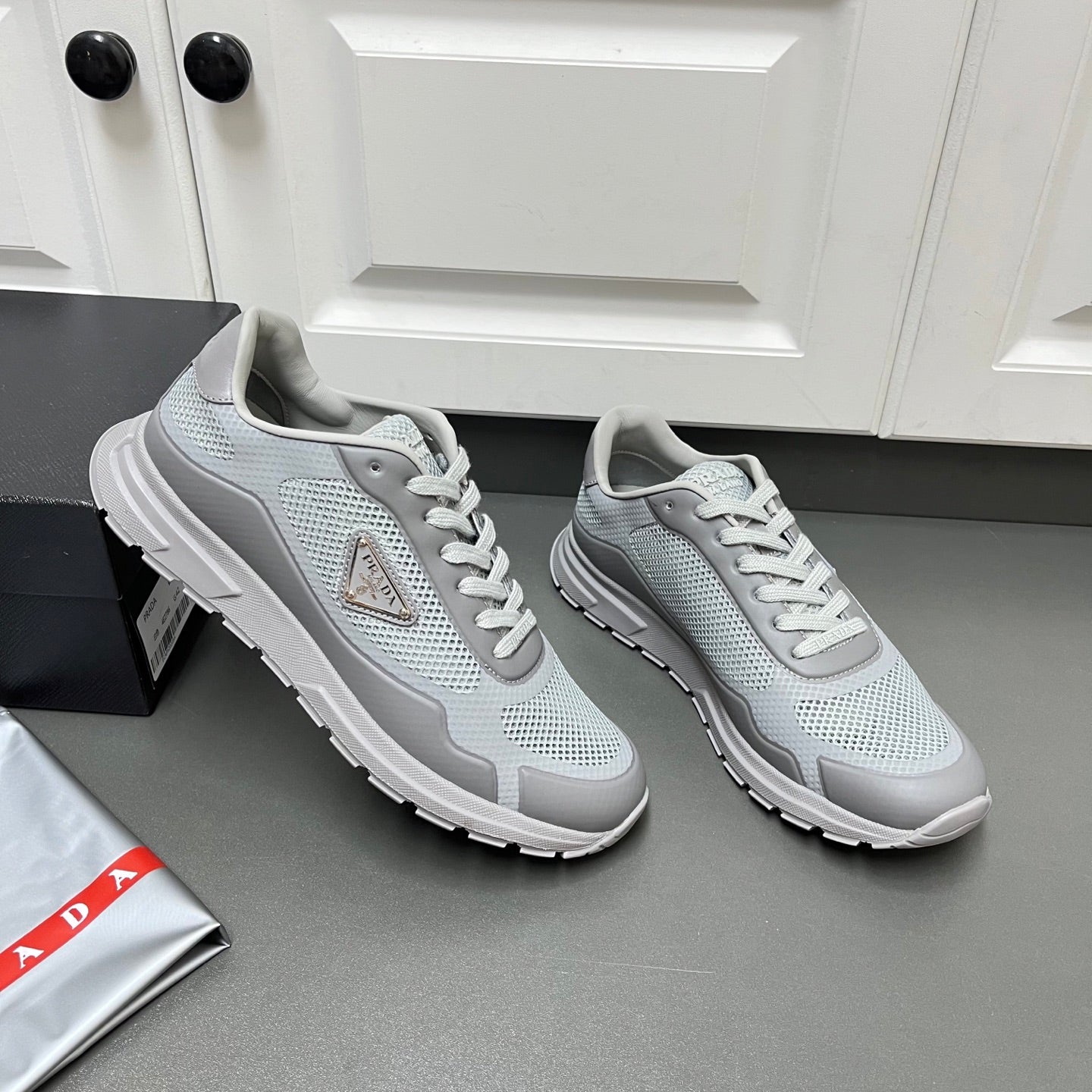 Prada unisex sneakers side view, light gray mesh with lace-up and tread sole