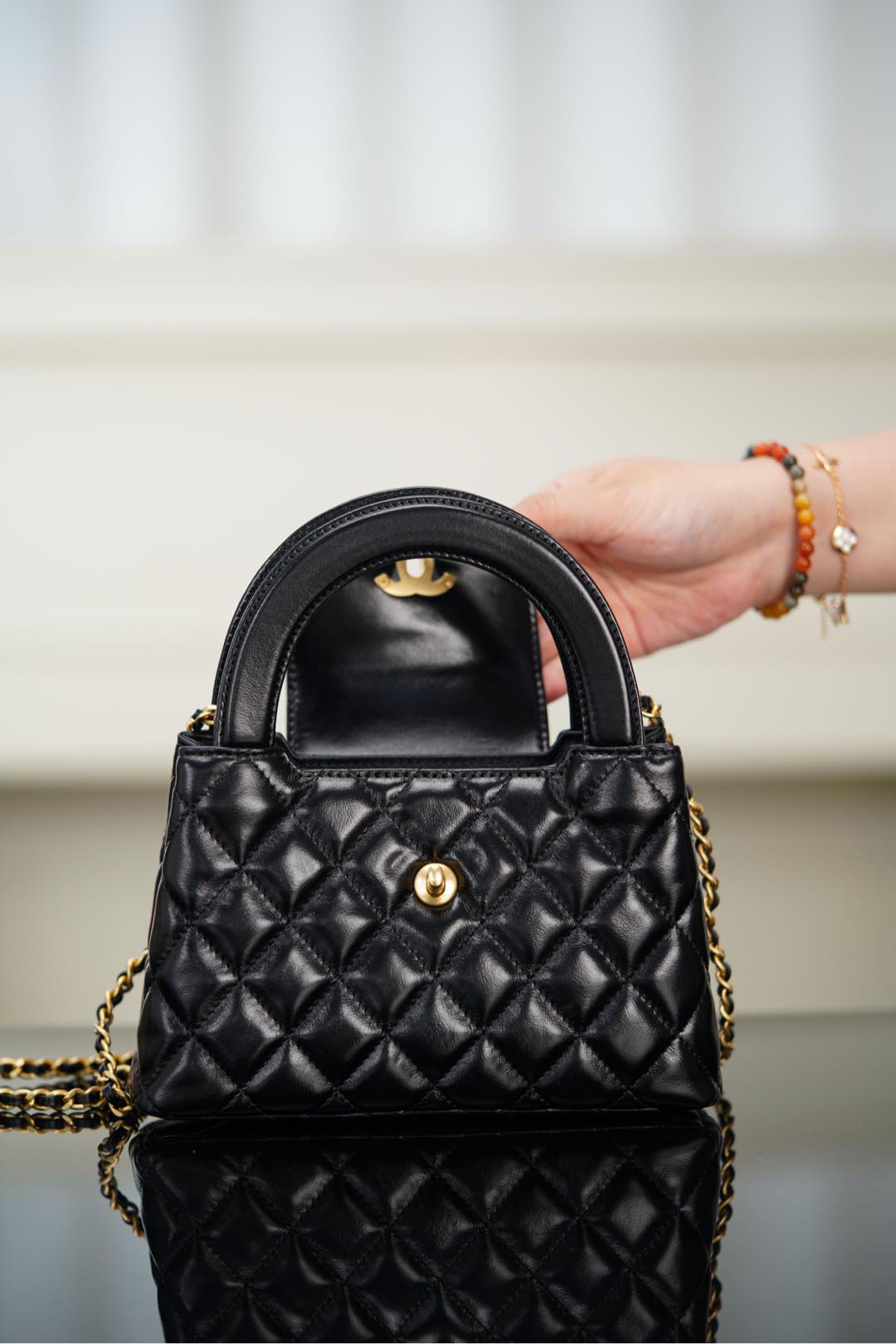 Black Chanel quilted mini handbag with CC clasp and gold chain shoulder strap