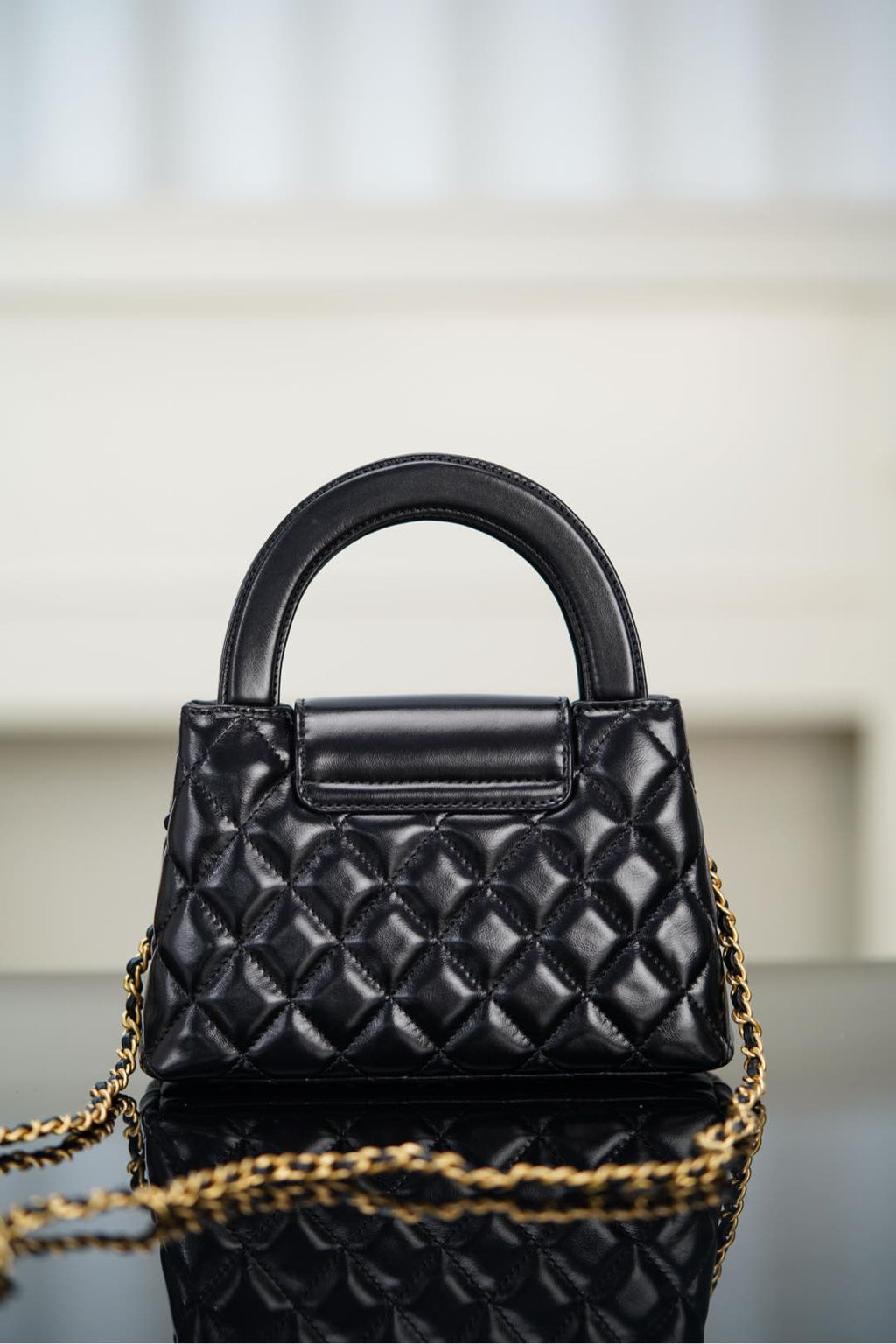 Black Chanel quilted mini handbag with front flap and chain shoulder strap