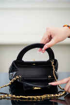 Black Chanel quilted mini handbag with side zipper pocket and chain strap