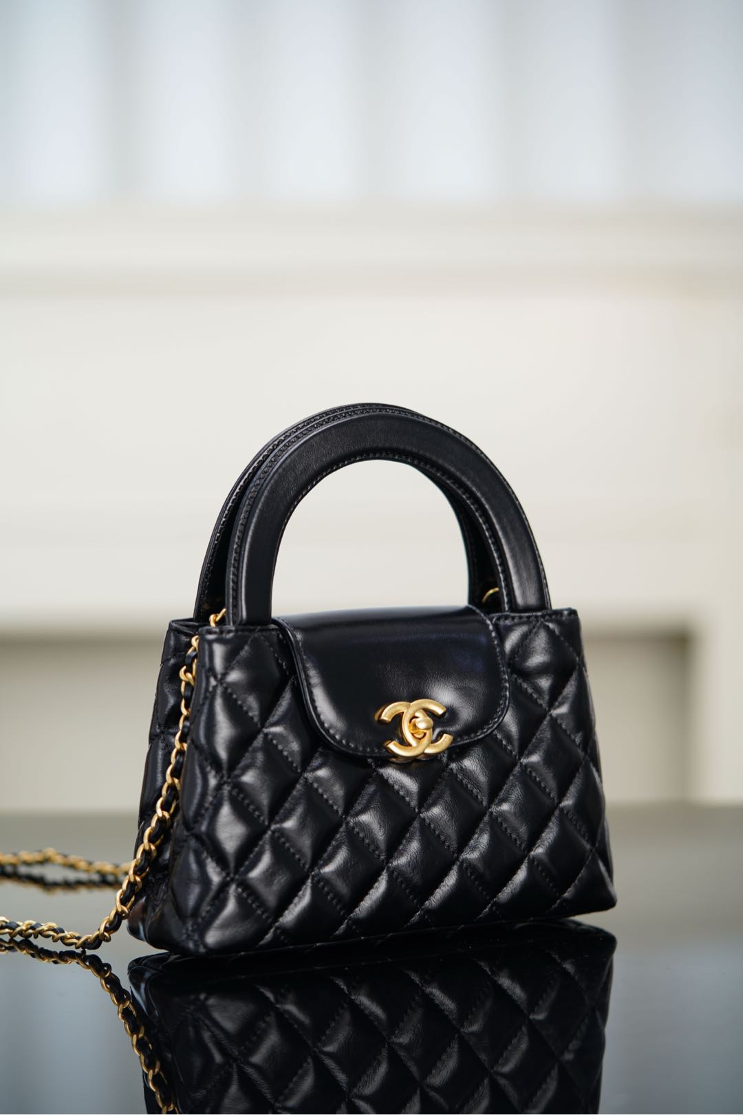 Black Chanel quilted mini handbag with CC logo medallion and chain strap