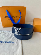 Blue leather Louis Vuitton belt with gold-tone LV buckle, upright on a surface