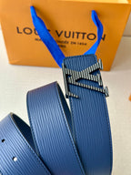 Blue leather belt close-up with gold-tone LV buckle and adjustable hole row