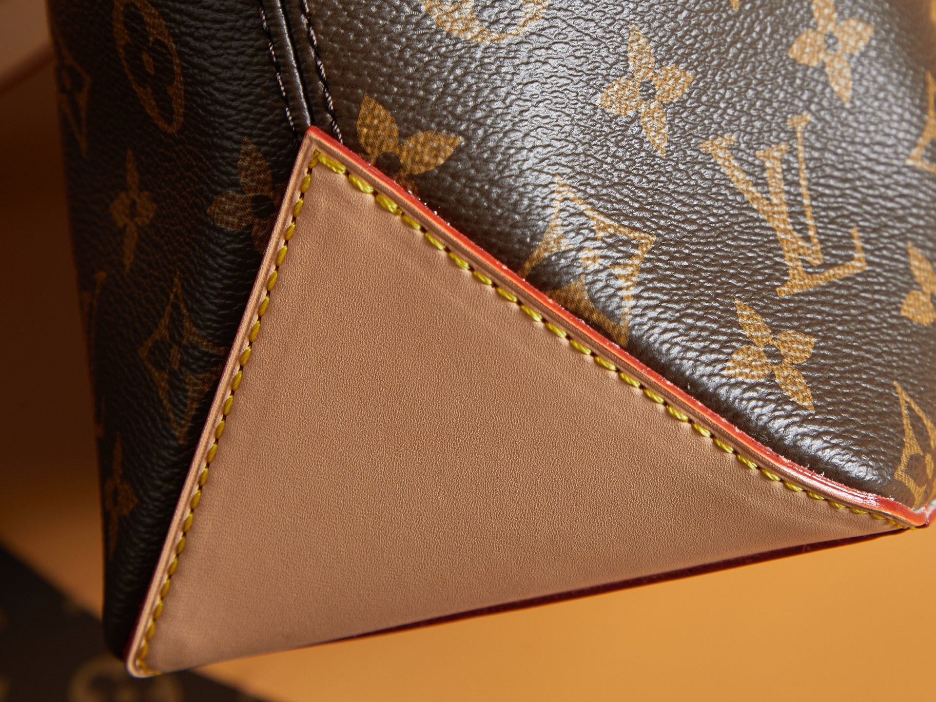 Louis Vuitton monogram corner with cream leather panel and multicolor stitching.