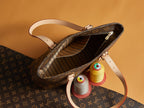 Louis Vuitton monogram bag open to striped interior with strap and gold hardware.