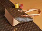 Louis Vuitton monogram satchel with cream leather sides, top zipper, and strap.