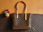 Louis Vuitton monogram tote bag with leather handles and adjustable shoulder strap.