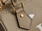 Louis Vuitton monogram handbag close-up: beige pebbled leather with leather tag and stitched edge