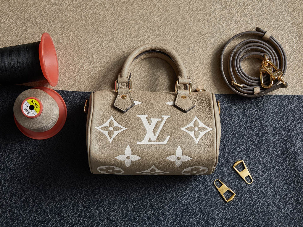 Louis Vuitton monogram handbag in beige with two top handles, gold hardware, and shoulder strap