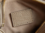 Louis Vuitton monogram handbag interior close-up: beige pocket panel with gold zipper teeth