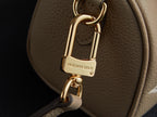 Louis Vuitton monogram handbag clasp close-up: gold padlock lock hardware on beige leather