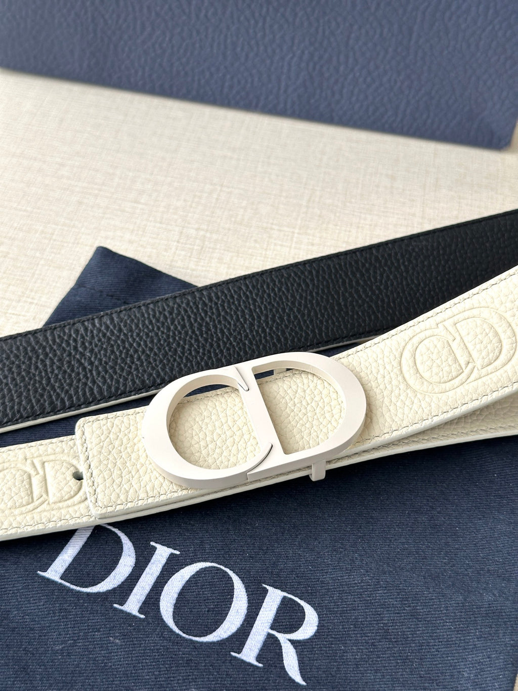 Dior belt close-up: cream leather with interlocking logo buckle