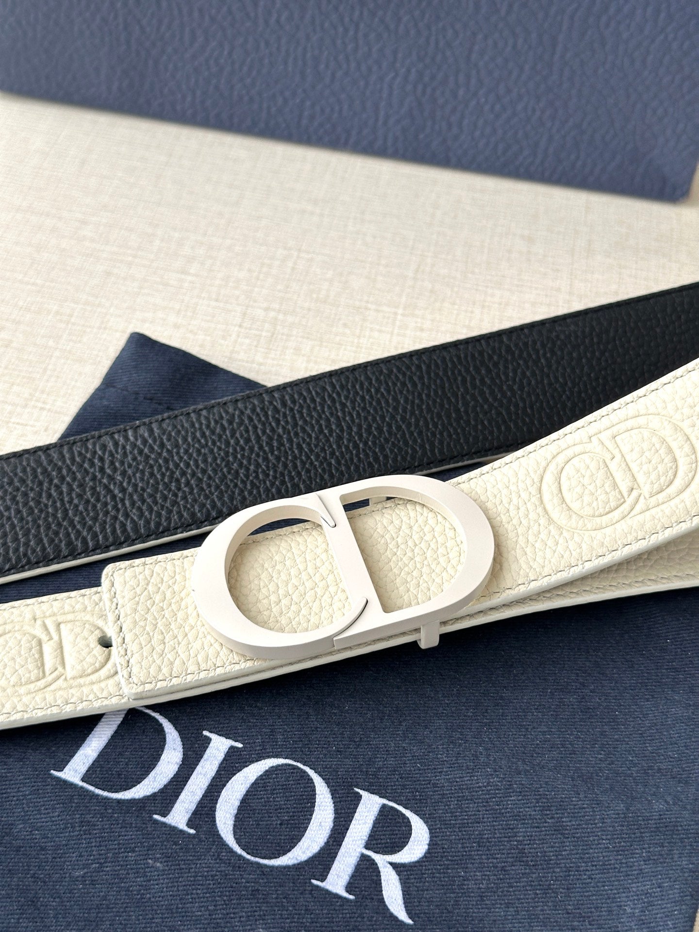 Dior belt close-up: cream leather with interlocking logo buckle