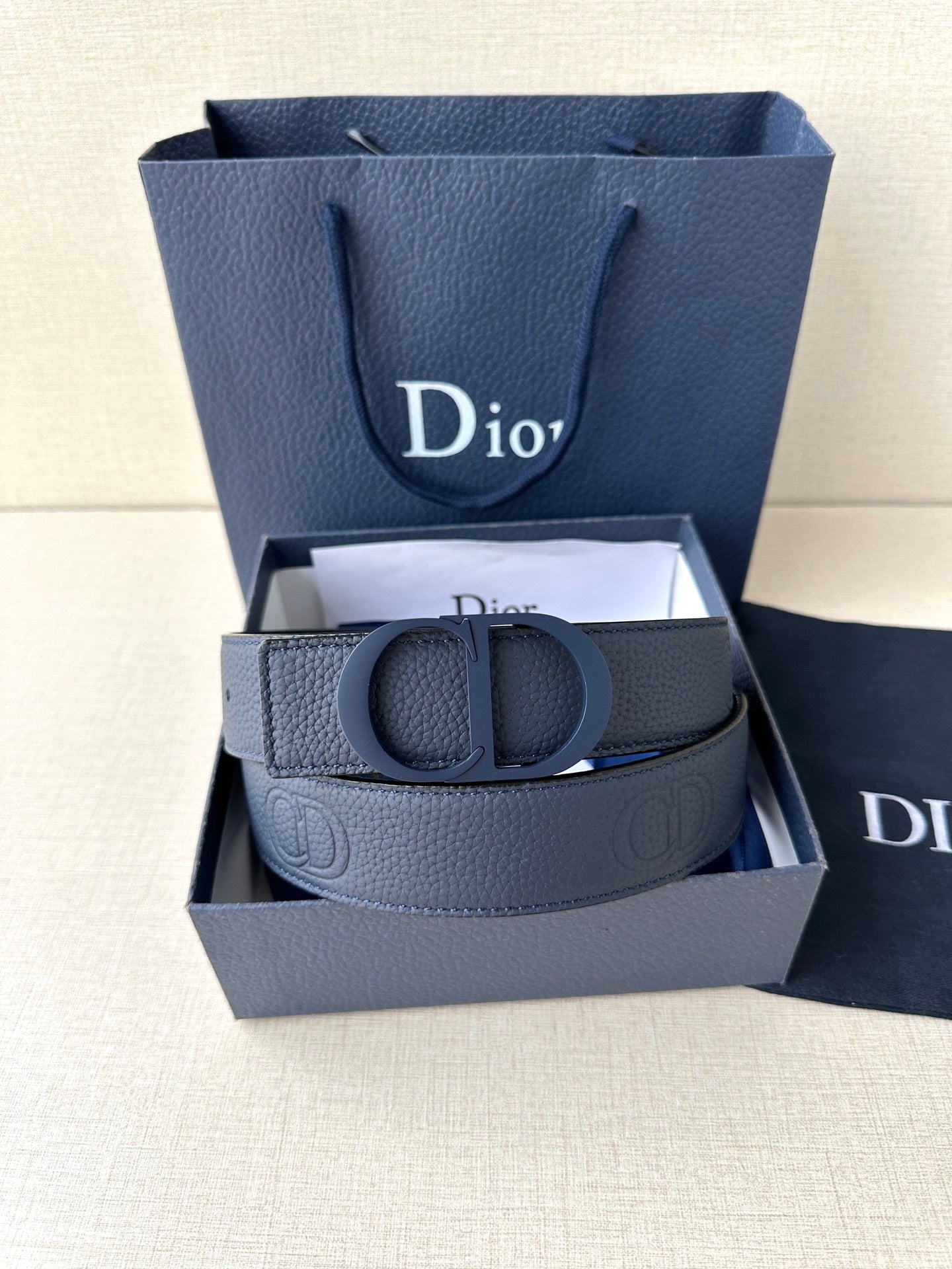 Blue leather Dior belt with CD clasp in gift box, folded strap ends visible