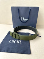Dior belt with olive green leather strap and round logo buckle, flat lay