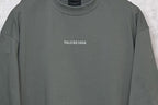 Balenciaga short-sleeve T-shirt close-up, dark gray-green crew neck and chest logo.