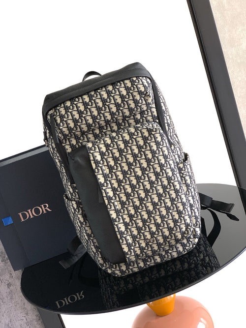 Dior men’s monogram backpack with black leather trim and adjustable shoulder straps