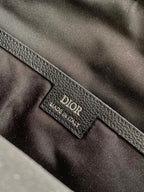 Dior logo leather interior label on gray-black bag lining, close-up