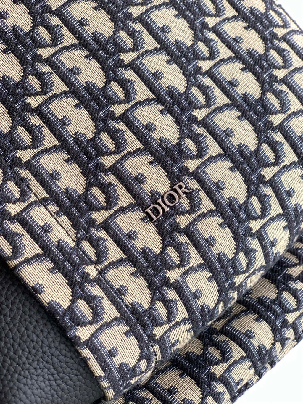 Dior monogram fabric panel on a backpack with stitched trim and Dior logo