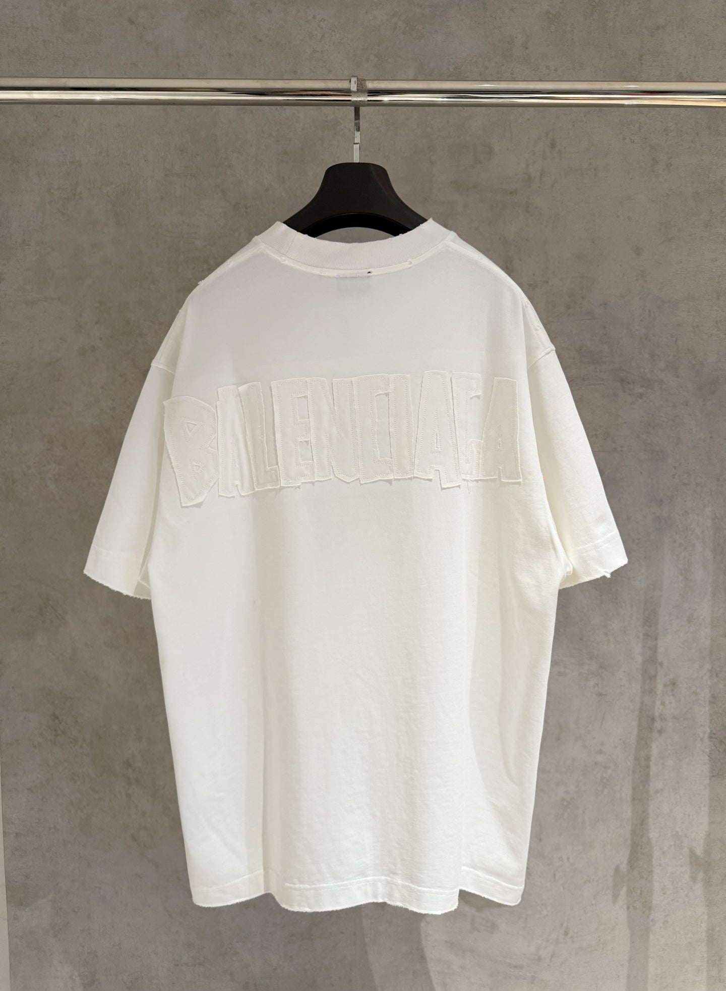 White Balenciaga T-shirt, back view with large embossed-style BALENCIAGA lettering