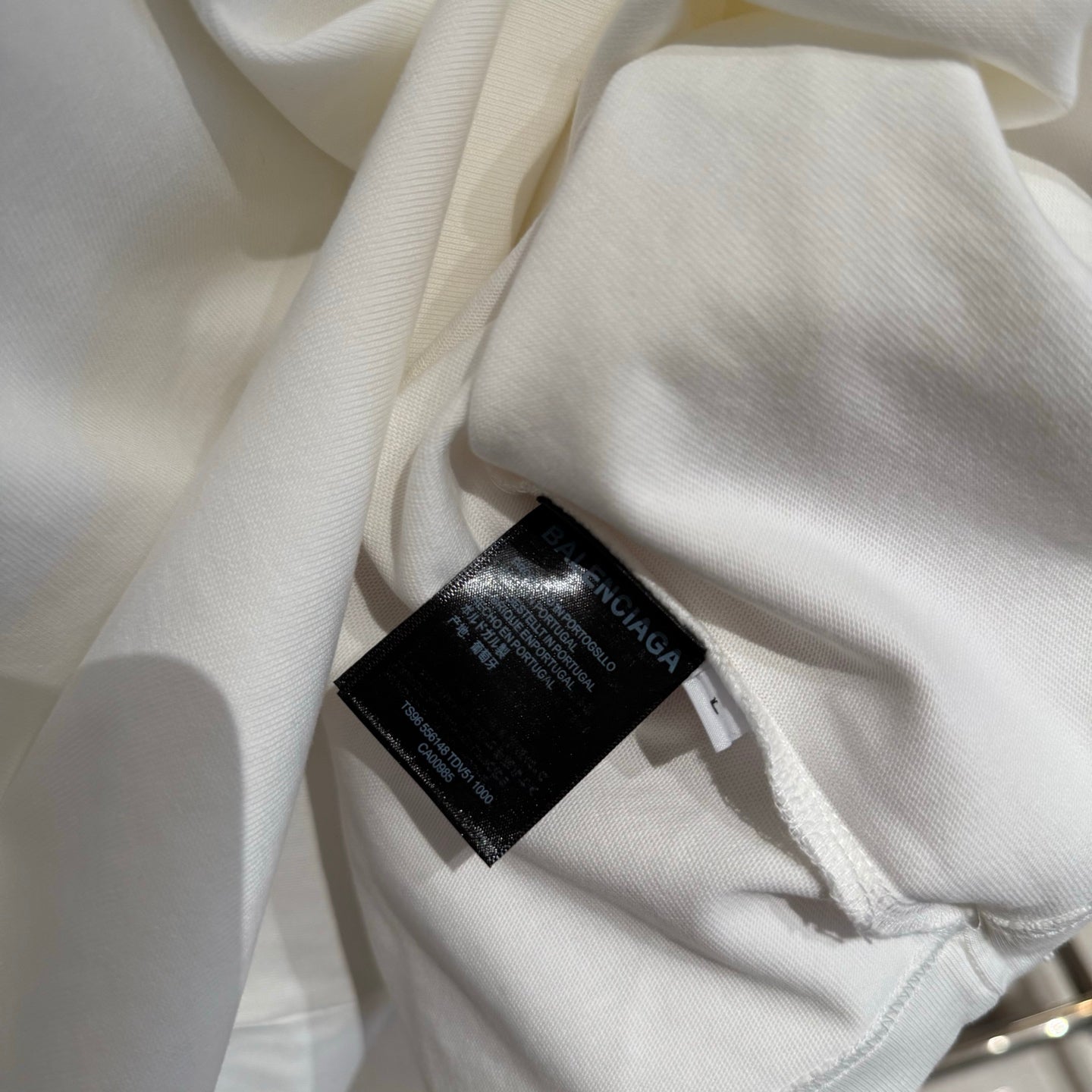 White Balenciaga T-shirt inner care label tag stitched near the side seam