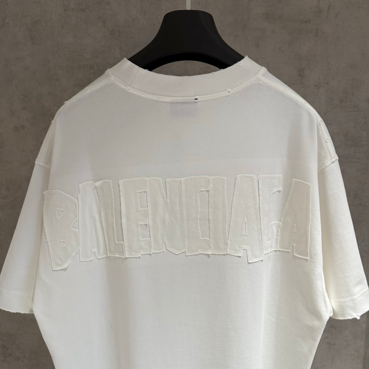White Balenciaga T-shirt with large embossed BALENCIAGA logo across the back