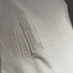 White Balenciaga T-shirt close-up of raised BALENCIAGA lettering on fabric