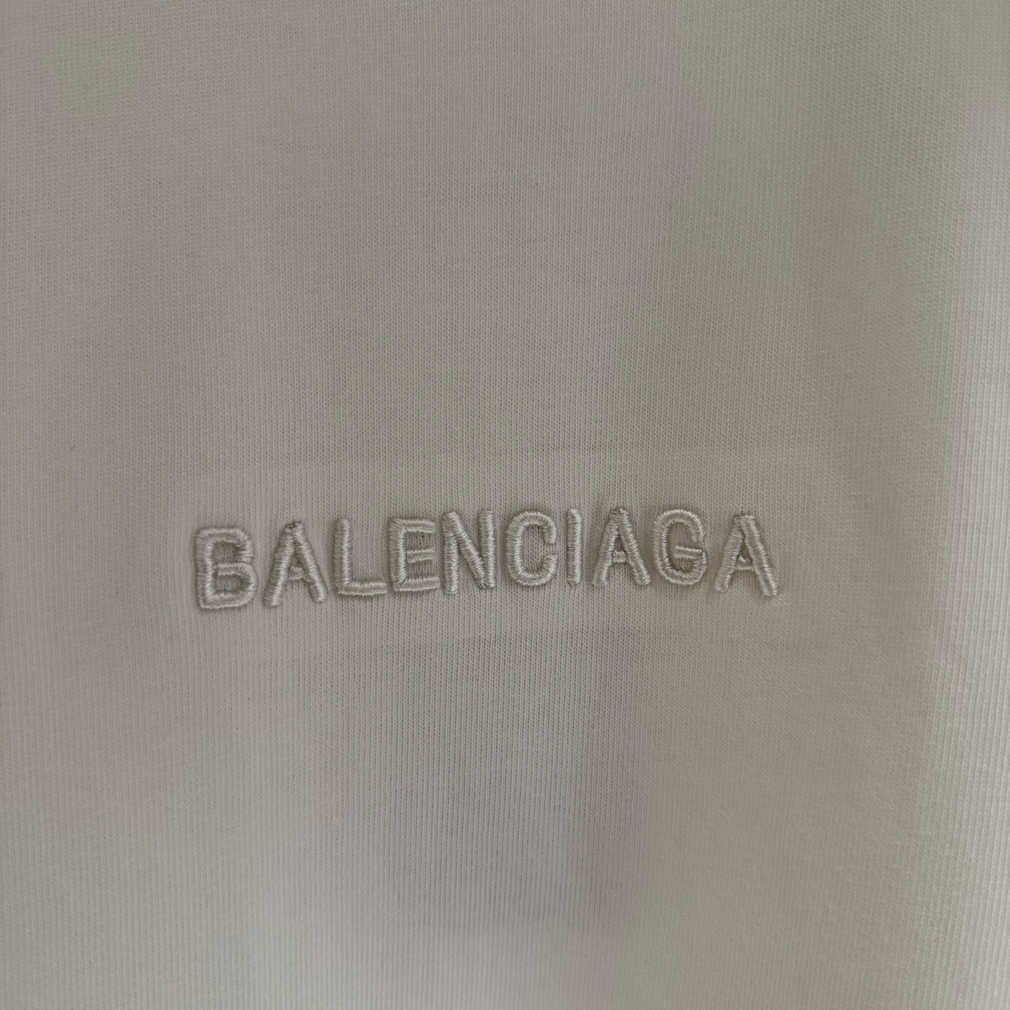 White Balenciaga T-shirt fabric close-up of BALENCIAGA logo embroidery