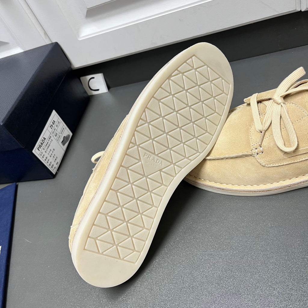 Beige suede loafers with textured rubber outsole and lace-up closure