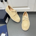 Beige suede lace-up loafers with moc-style stitching and flat white rubber sole