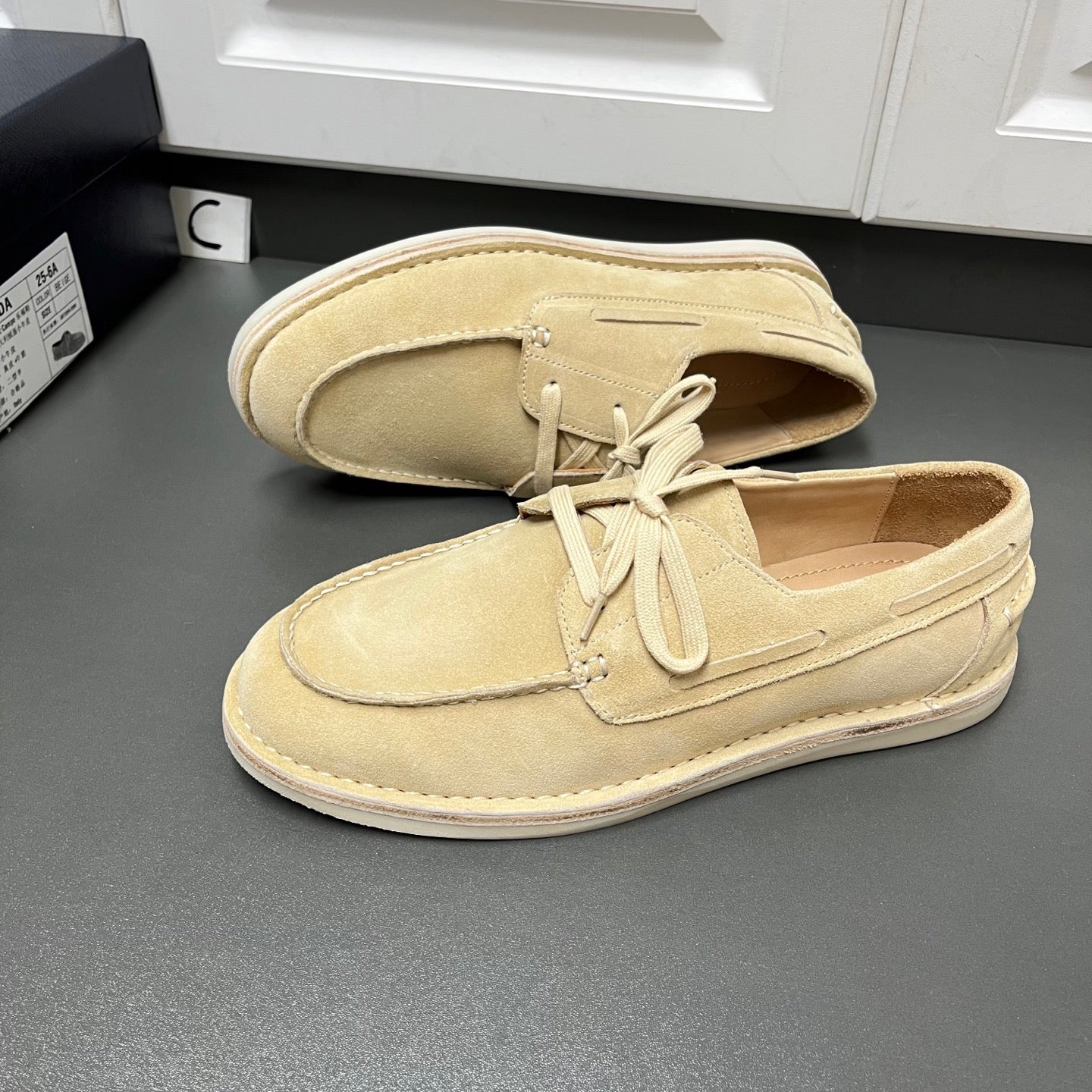 Beige suede lace-up loafers, side view, with white rubber sole and lace-up vamp