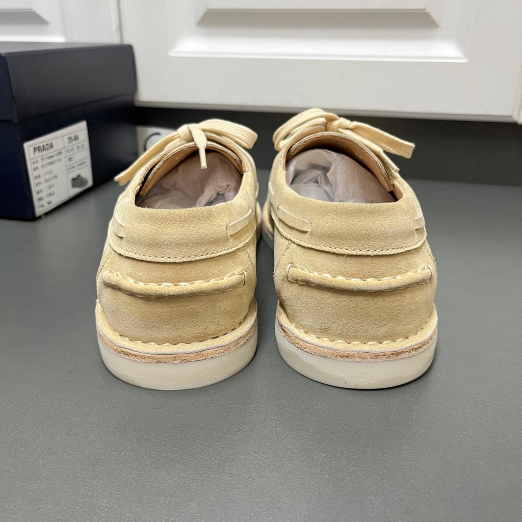 Beige suede lace-up shoes from the back with white midsoles and looped laces