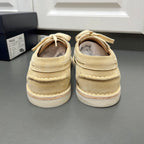 Beige suede lace-up shoes from the back with white midsoles and looped laces