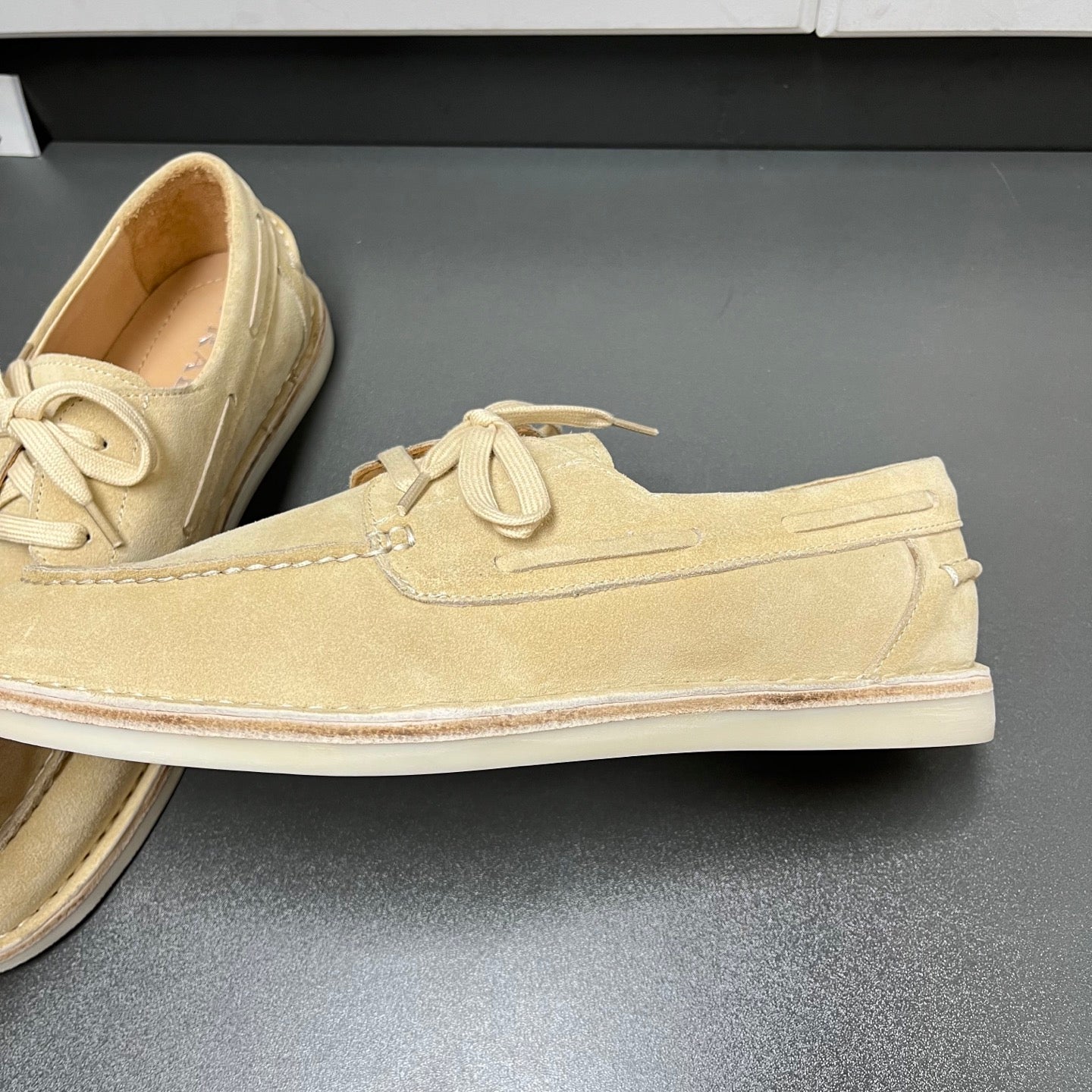 Beige suede lace-up loafer with textured seam detailing and flat white sole