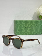 Round sunglasses with tortoiseshell frames and dark greenish lenses