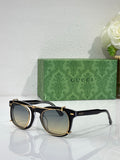 Round sunglasses with black and gold frames, dark lenses