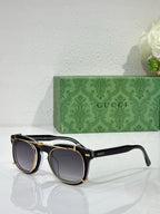Round sunglasses with black frames and dark lenses, gold-tone accents