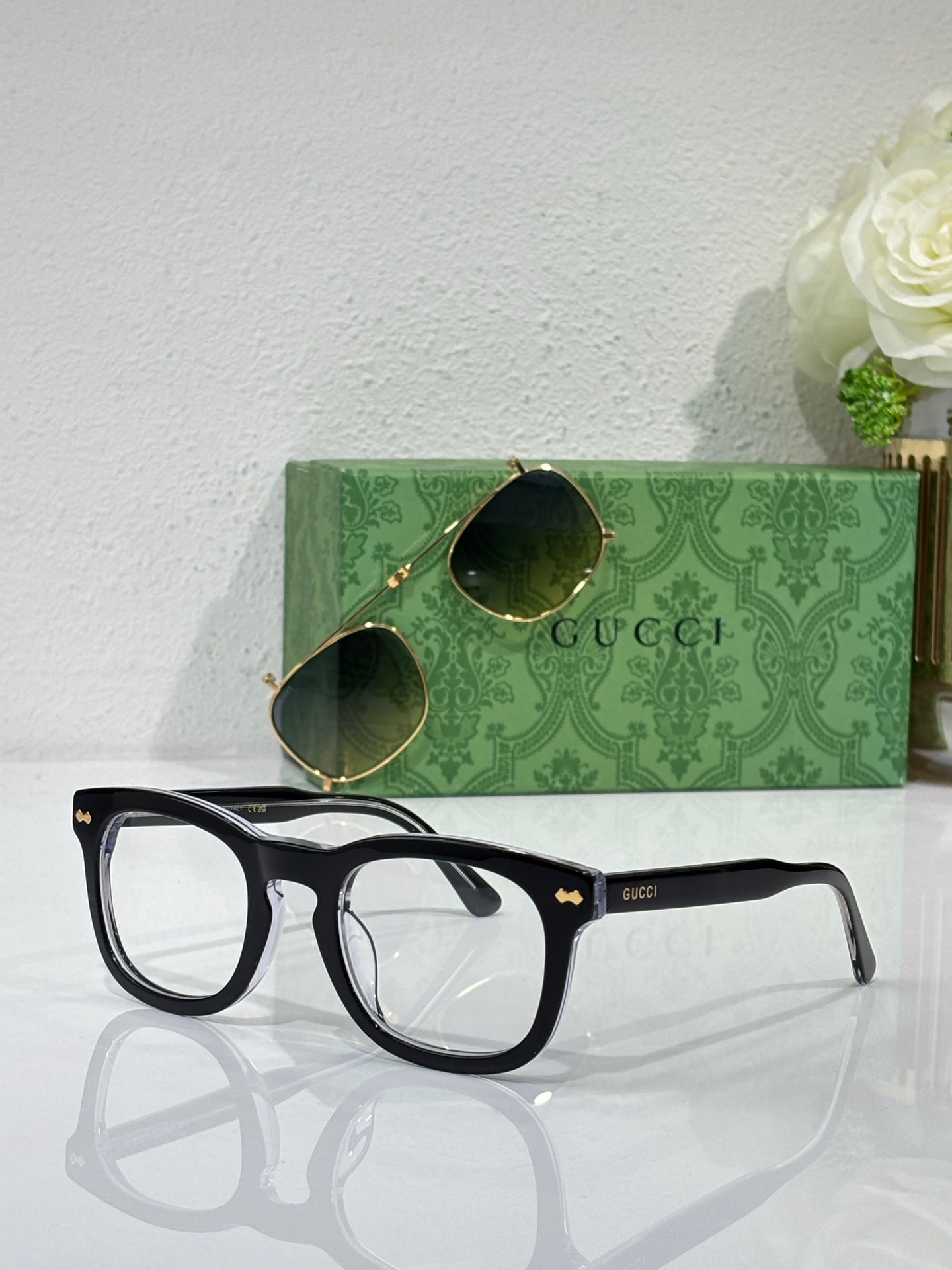 Black rectangular eyeglasses with clear lenses and Gucci logo on temple arms