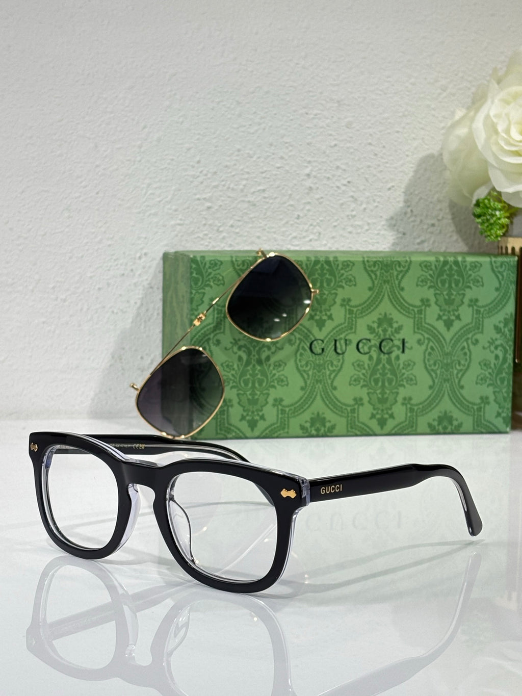 Black rectangular eyeglasses with clear lenses and Gucci logo on temple arms