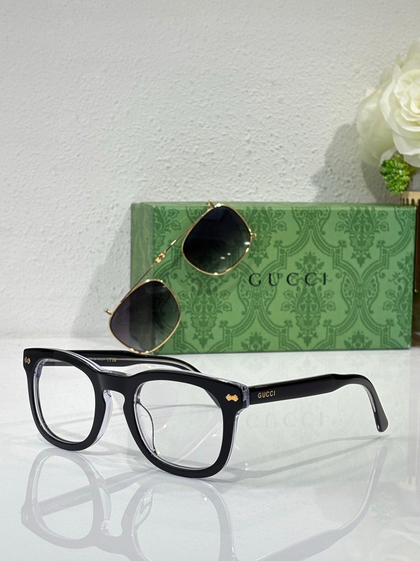 Black rectangular eyeglasses with clear lenses and Gucci logo on temple arms