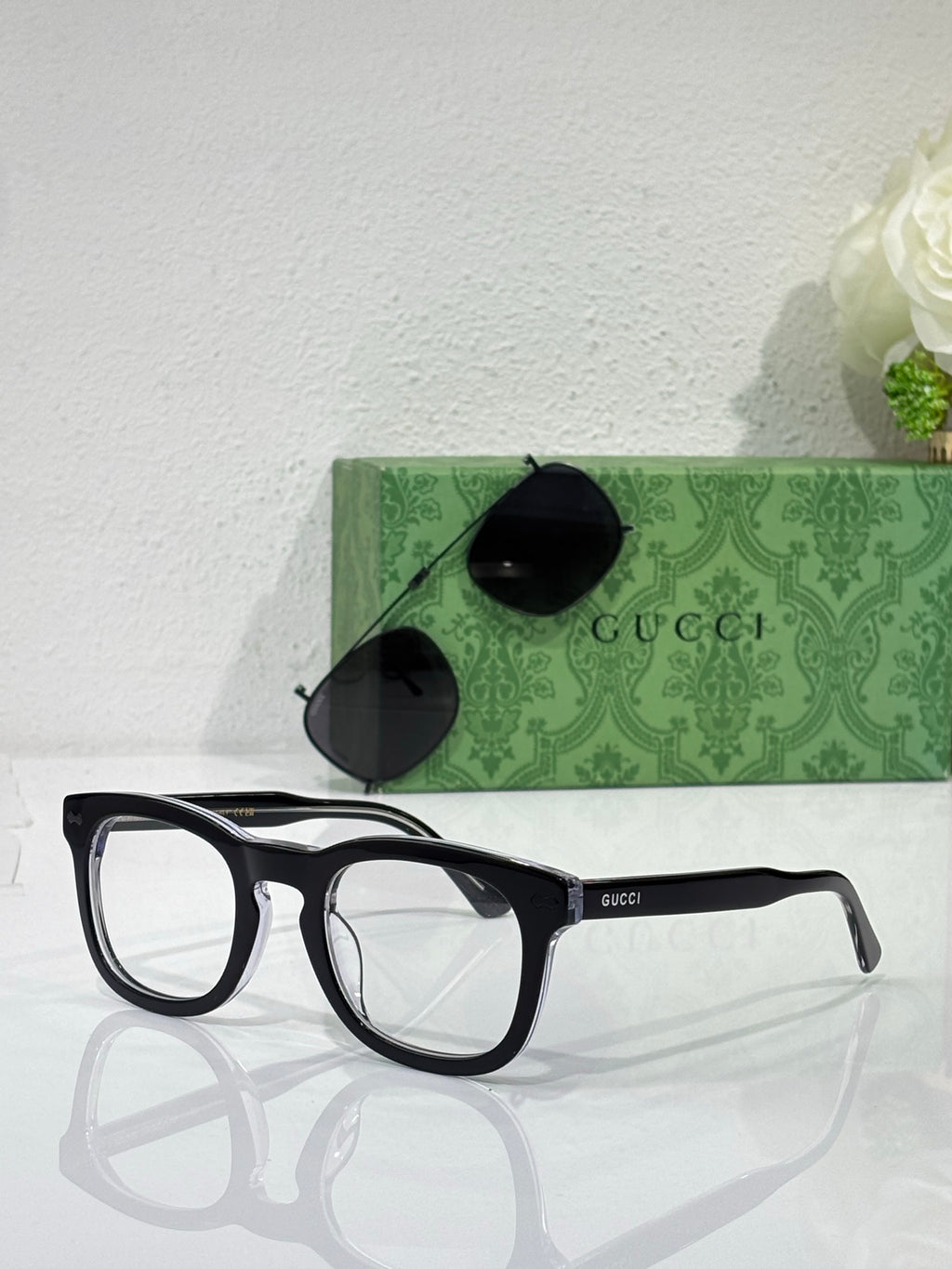 Black rectangular eyeglasses with clear lenses and Gucci logo on temple arms