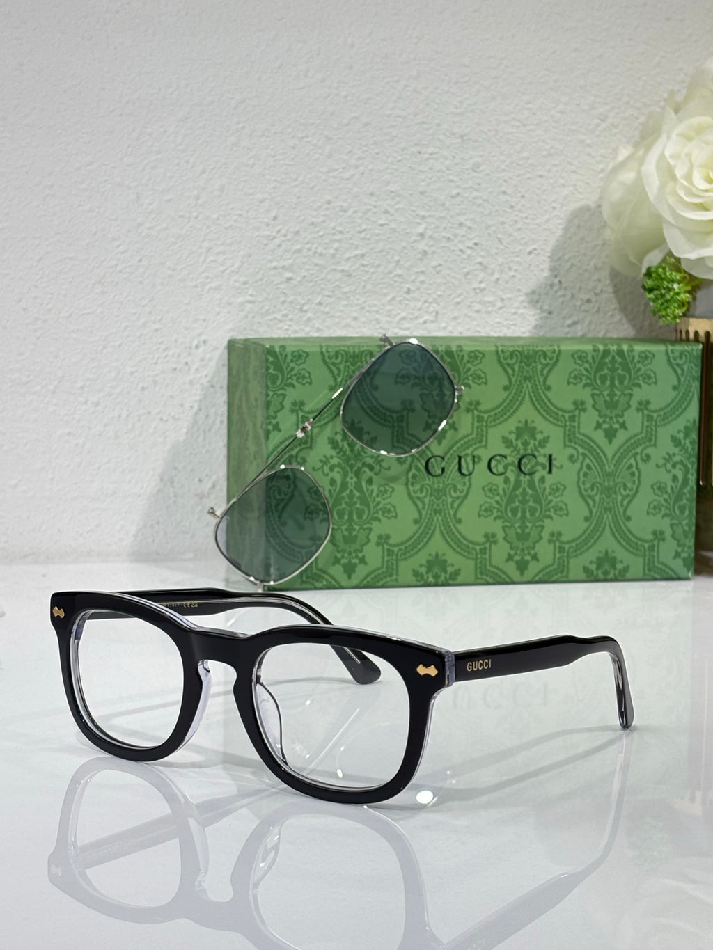 Black rectangular eyeglasses with clear lenses and Gucci logo on temple arms
