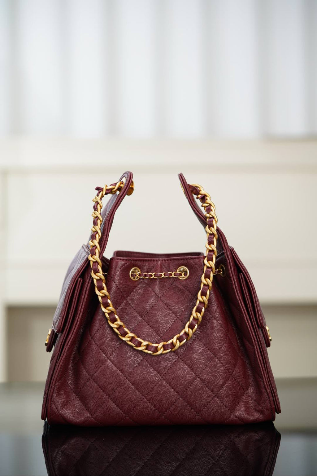 Chanel quilted shoulder bag in dark red with gold chain strap and top handle hardware