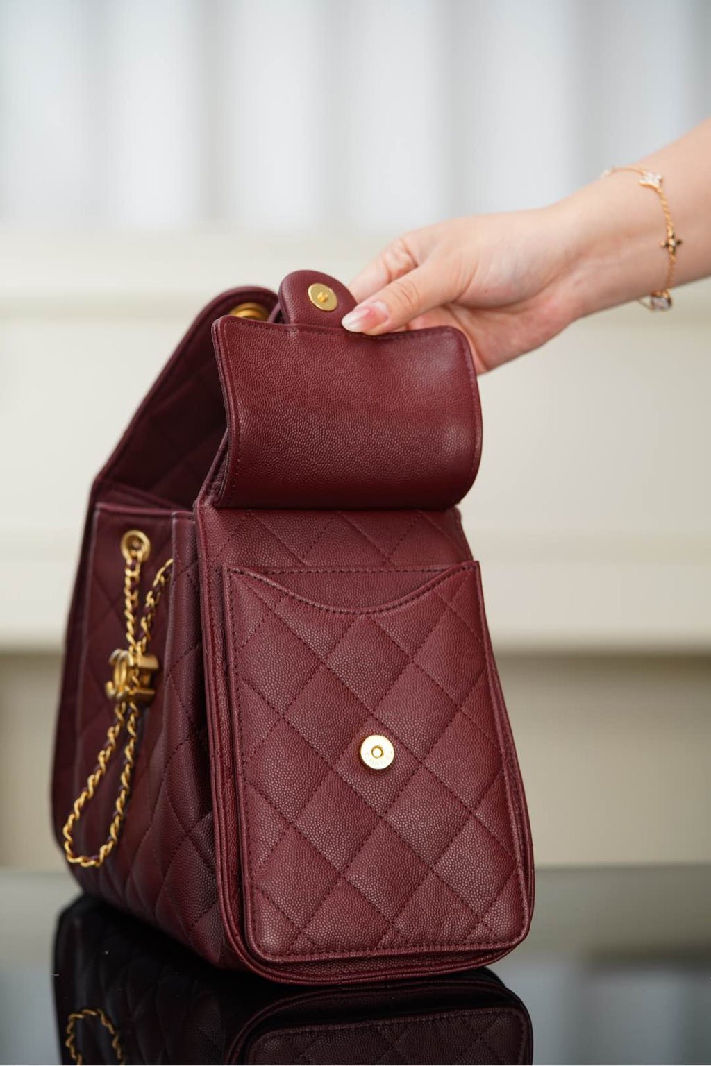 Chanel quilted mini bag in dark red with flap opening and gold chain strap; CC button