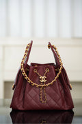 Chanel quilted shoulder bag in dark red with gold chain handles and CC logo charm