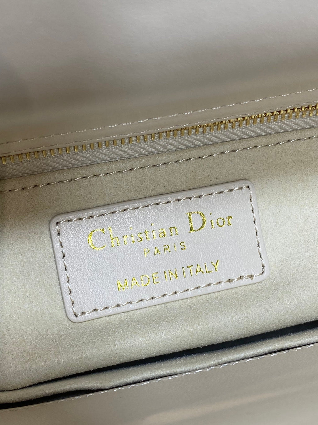Christian Dior label reading MADE IN ITALY on white Dior handbag