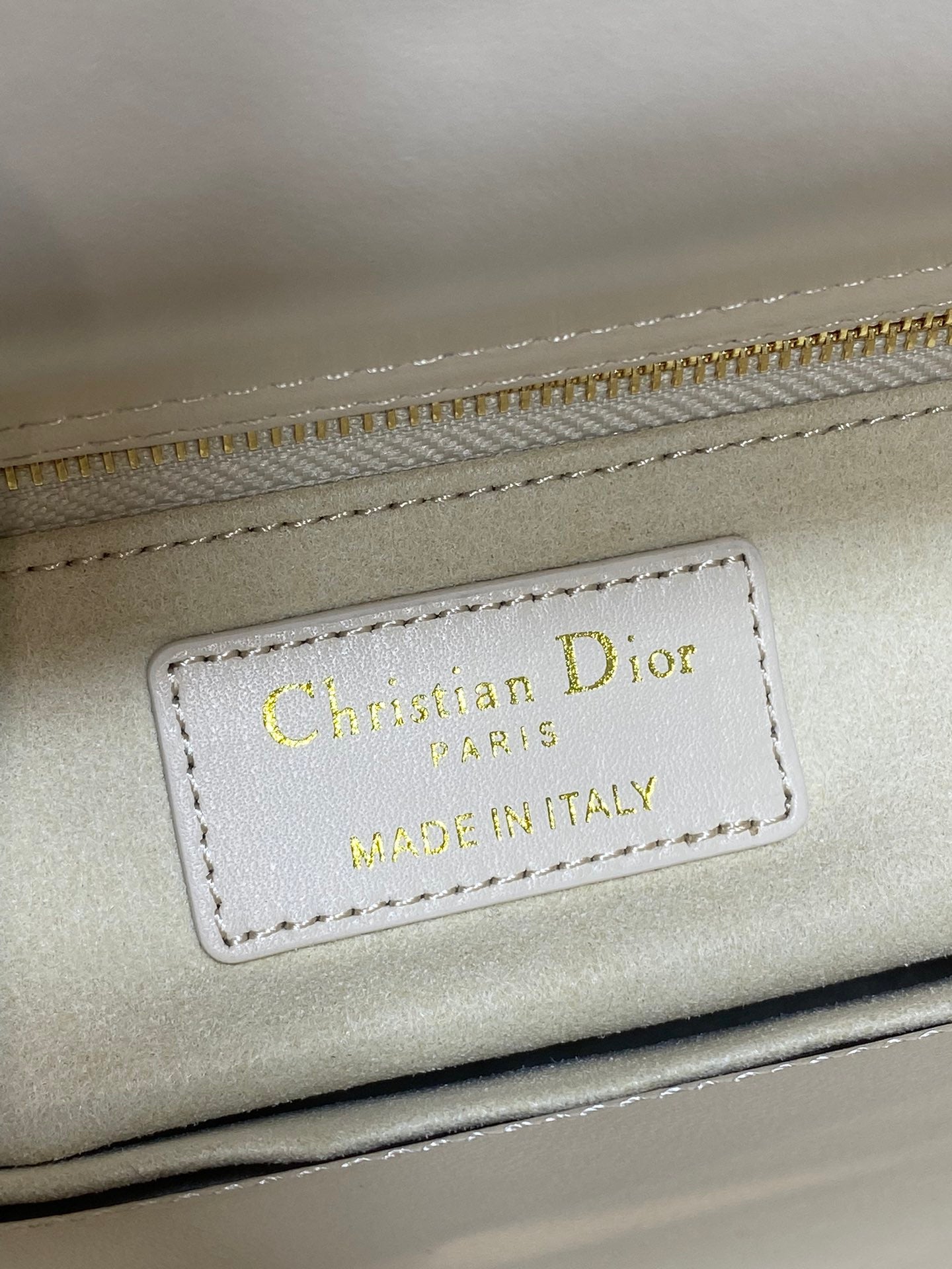 Christian Dior label reading MADE IN ITALY on white Dior handbag