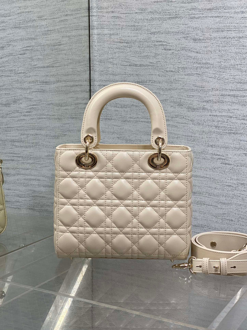 Cream quilted Dior handbag with top handles and shoulder strap