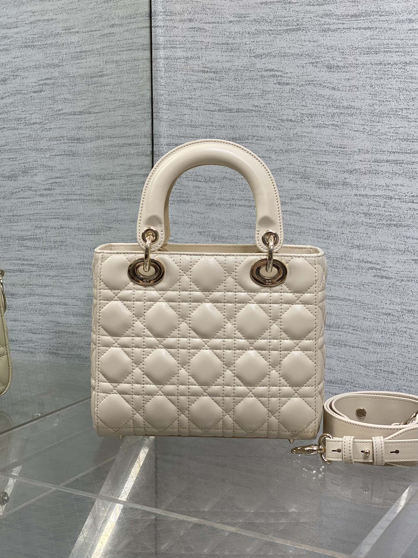 Cream quilted Dior handbag with top handles and shoulder strap