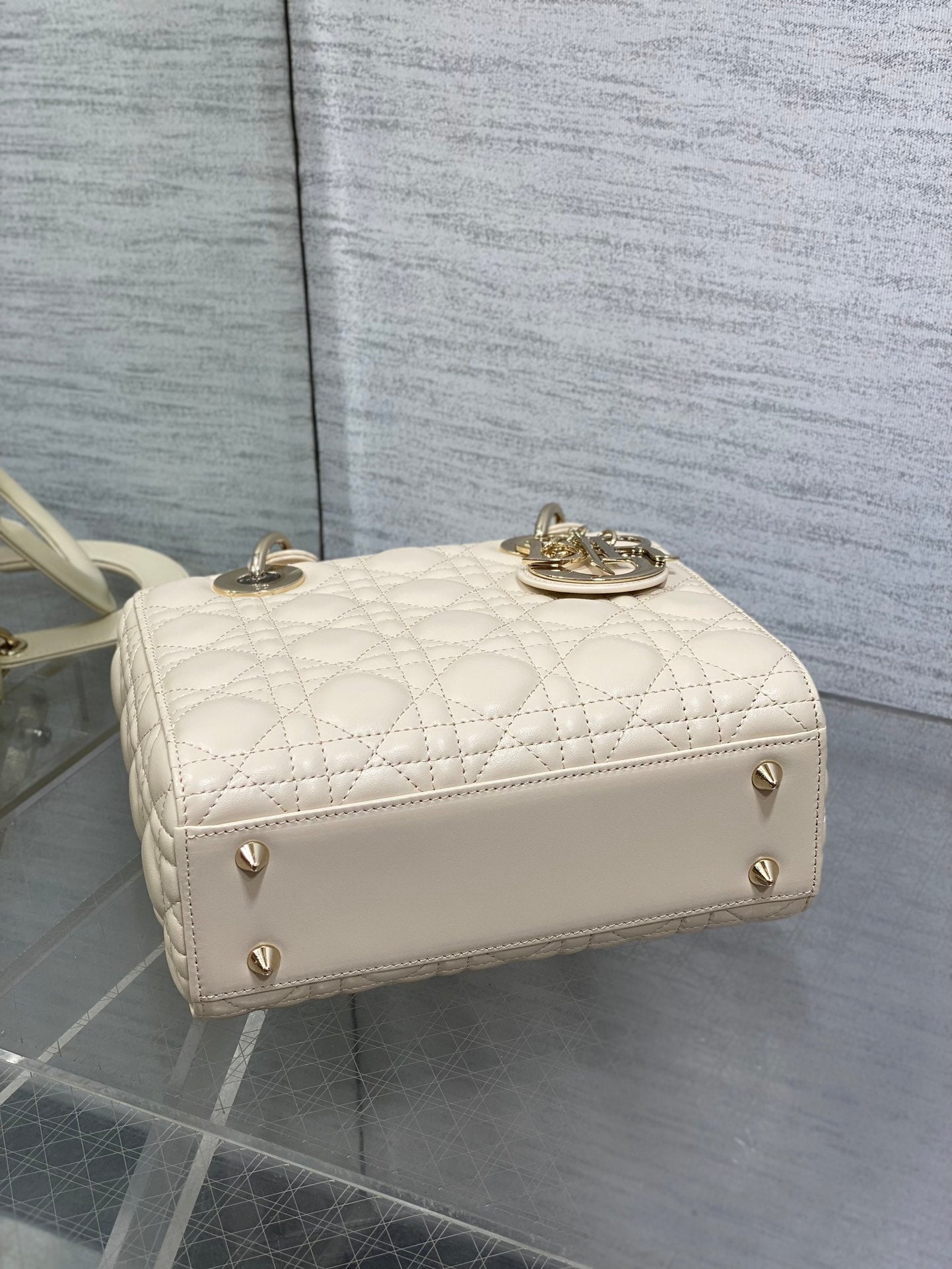 White Dior quilted clutch with gold-tone studs and rounded flap